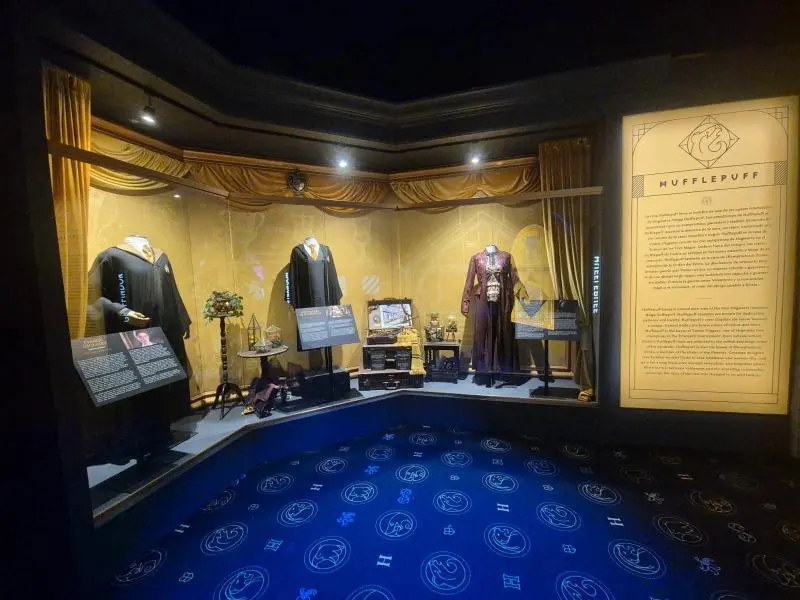 Los trajes y objetos en exposición de la zona dedicada a Hufflepuff.